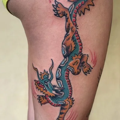 American traditional dragon tattoo on thigh with bold colors by Waikiki tattooer Dustin Gormley